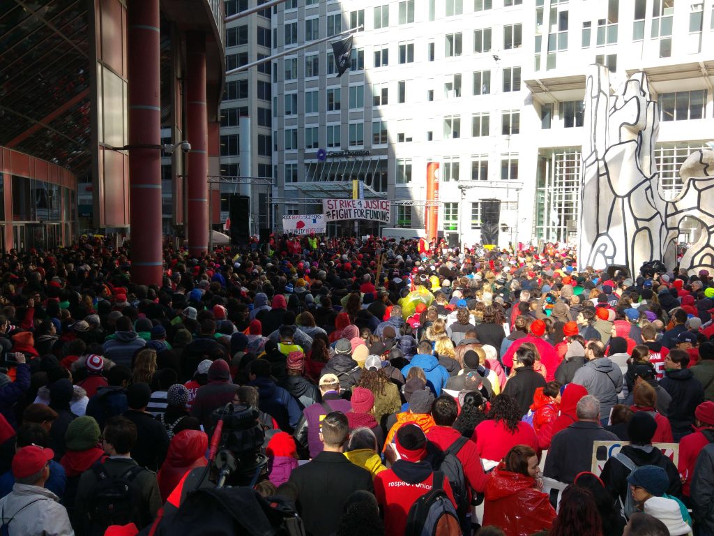 Chicago teachers' rally 1 April 2016, banners read "Strike 4 Justice, Fight For Funding" and "Rock Beats Scissors, Solidarity Beats Cuts"