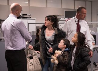 Actor Hayley Squires and two child actors surrounded by two men dressed as security guards in a scene of the film 'I, Daniel Blake'