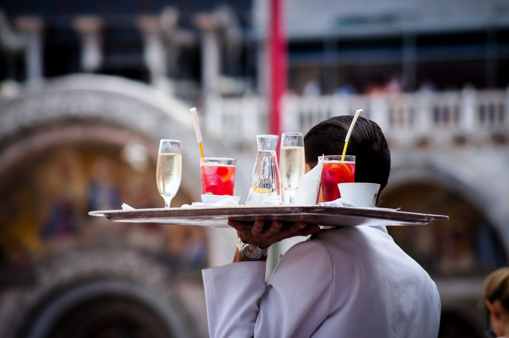 A waiter carrying a large tray of beverages