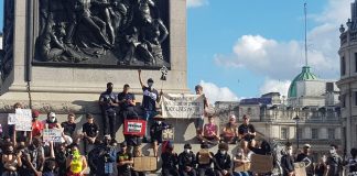 Protesters at a Black Lives Matter demonstration in London, standing around Nelson's Column with banners.