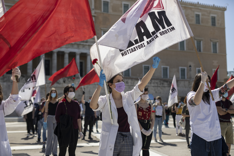 Protestors wave flags at a socially distanced May Day protest in Athens