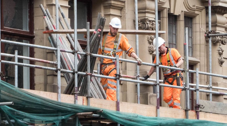 An image of two construction workers on a scaffold. Keywords: Covid coronavirus shut the sites unsafe work safety