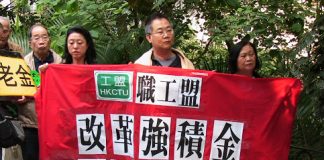 Image shows activists from the Hong Kong Confederation of Trade Unions holding up a flag.