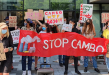 Protestors at a rally against developing the Cambo oil field, holding placards and a banner reading 'stop cambo'