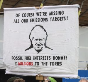 Banner reads: of course we're missing all our emissions targets! Fossil fuel interests donate £millions to the Tories