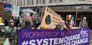 Banner reads: Workers of the world, unite! #System Change Not Climate Change