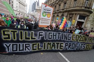 Banner reads: still fighting co2onialism. Your profits kill