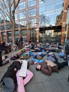 photo shows trans protestors staging die-in at NHS england