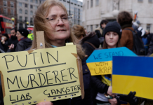Protest in London on 6 March 2022. Placard reads 'Putin is murder, liar, gangster.' Ukraine flag in background. Photo by Steve Eason.
