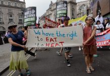 Protesters carry banner, "we have the right to eat, to heat"
