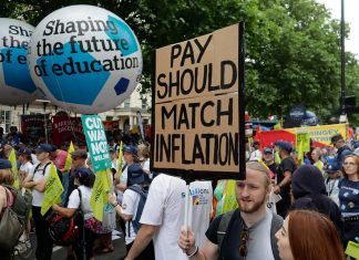 Marchers on TUC protest with "pay should match inflation" placard