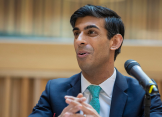 A photo of Rishi Sunak in front of a microphone from HM treasury.