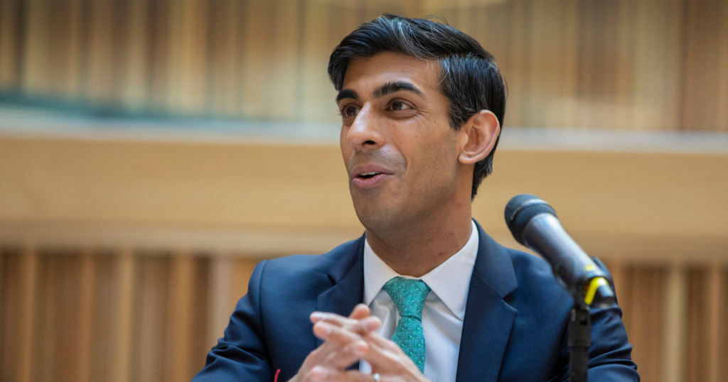 A photo of Rishi Sunak in front of a microphone from HM treasury.
