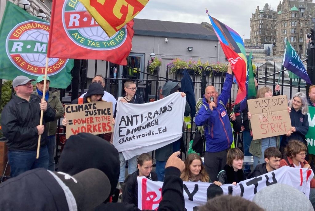 Забастовщики, протестующие против климата, активисты против рейдов, Unison, члены Unite, радужный флаг на пикете станции Уэверли, Эдинбург