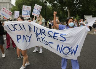Nurses hold a banner reading "UCH nurses: pay rise now"