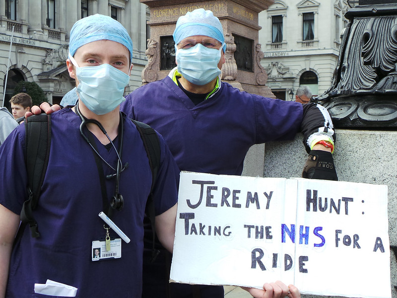 Медики в халатах с плакатами "Джереми Хант: прогулка по NHS"