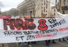 Image shows a banner reading 'Paris 8 en lutte: faisons battre en retraite Macron et les patrons'. In English this means 'make Macron and the bosses retreat', though it is also a pun on retirement ('la retraite').