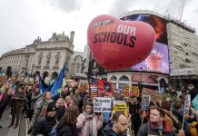 crowds march in London with a big heart shaped NEU balloon