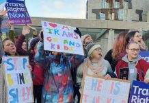 a collection of people holding placards saying 'I Love my trans grandkids', and other messages of trans support.