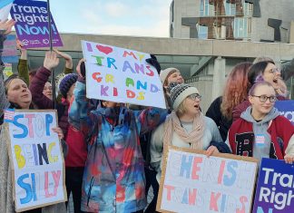 a collection of people holding placards saying 'I Love my trans grandkids', and other messages of trans support.